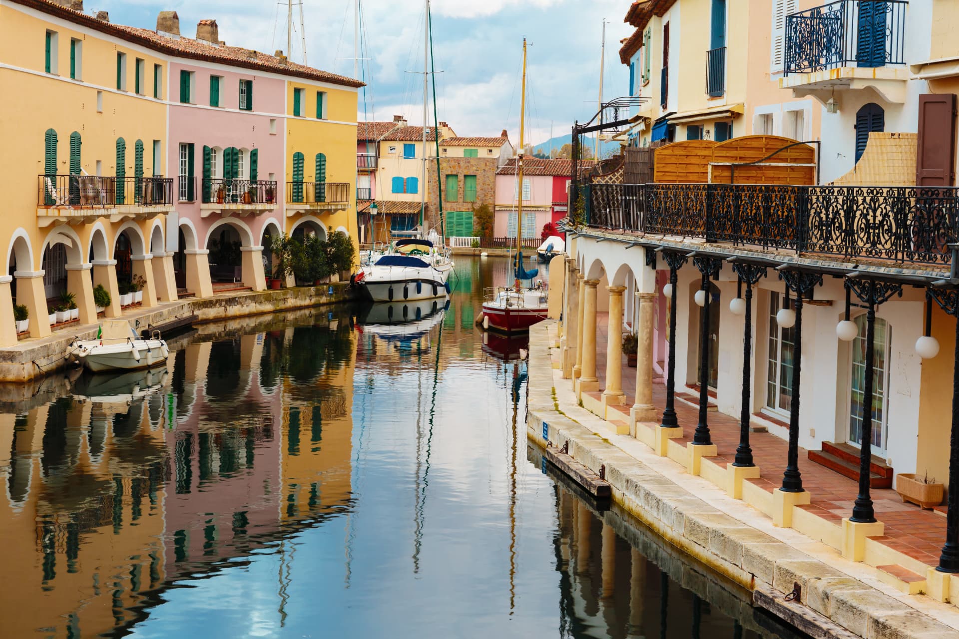 Canaux bordés de maisons colorées à Port Grimaud, reflétées dans l'eau calme
